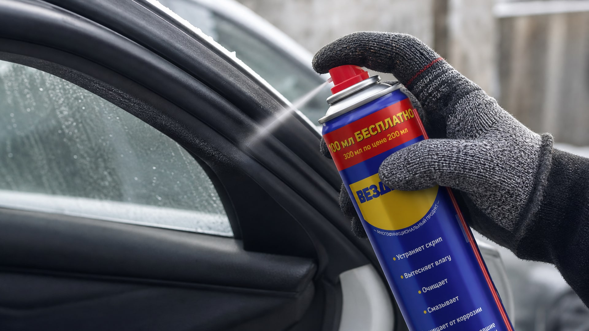 Рука в перчатке наносит универсальную смазку WD-40 на уплотнители.